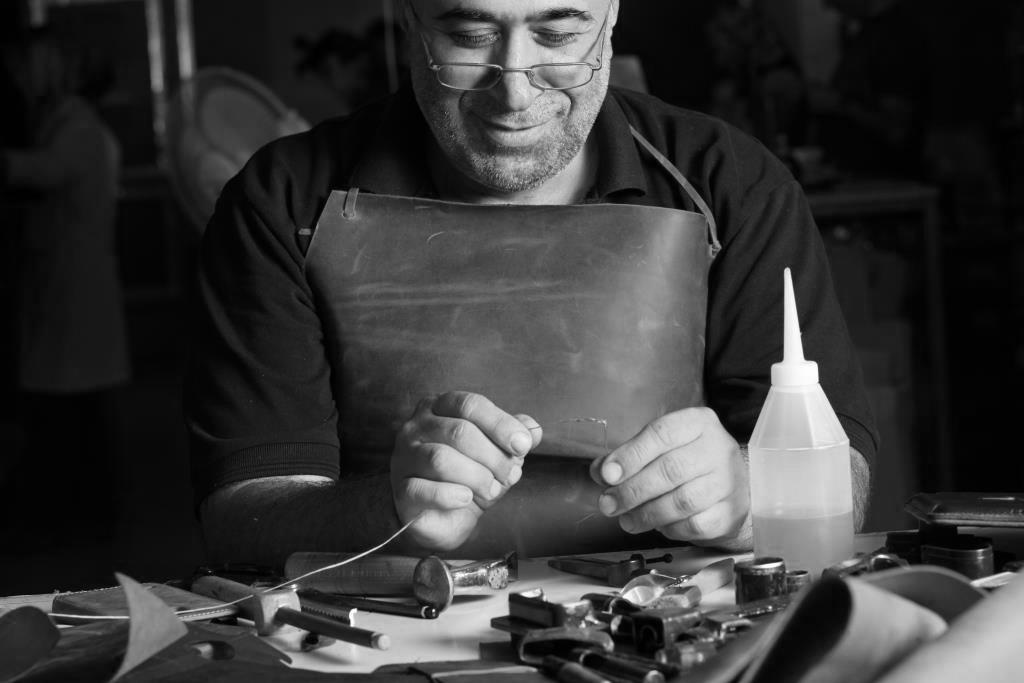 british leather artisan making phone case wallet